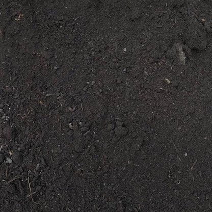 A close-up view of a dark, moist soil mixture, a garden compost, and a soil conditioner.